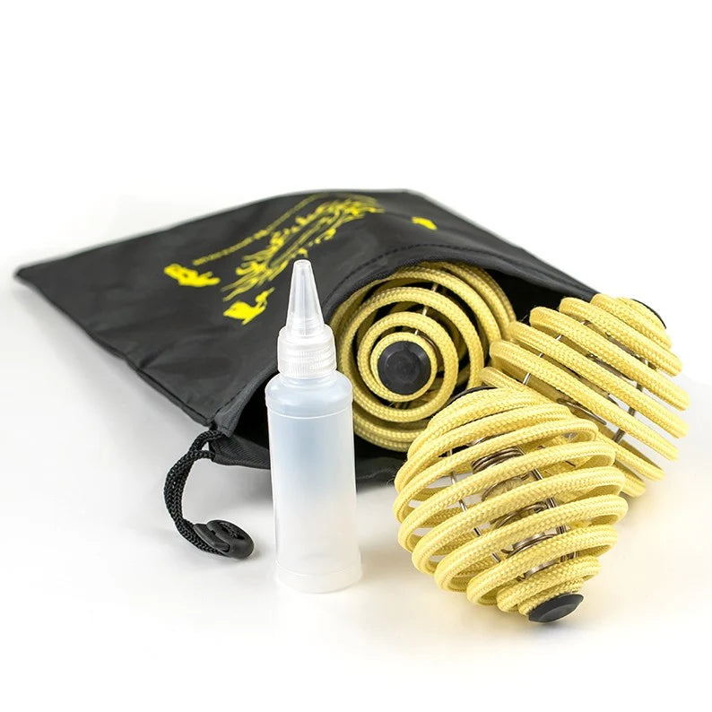 A set of three yellow fire juggling balls alongside a fuel bottle and a black carrying pouch
