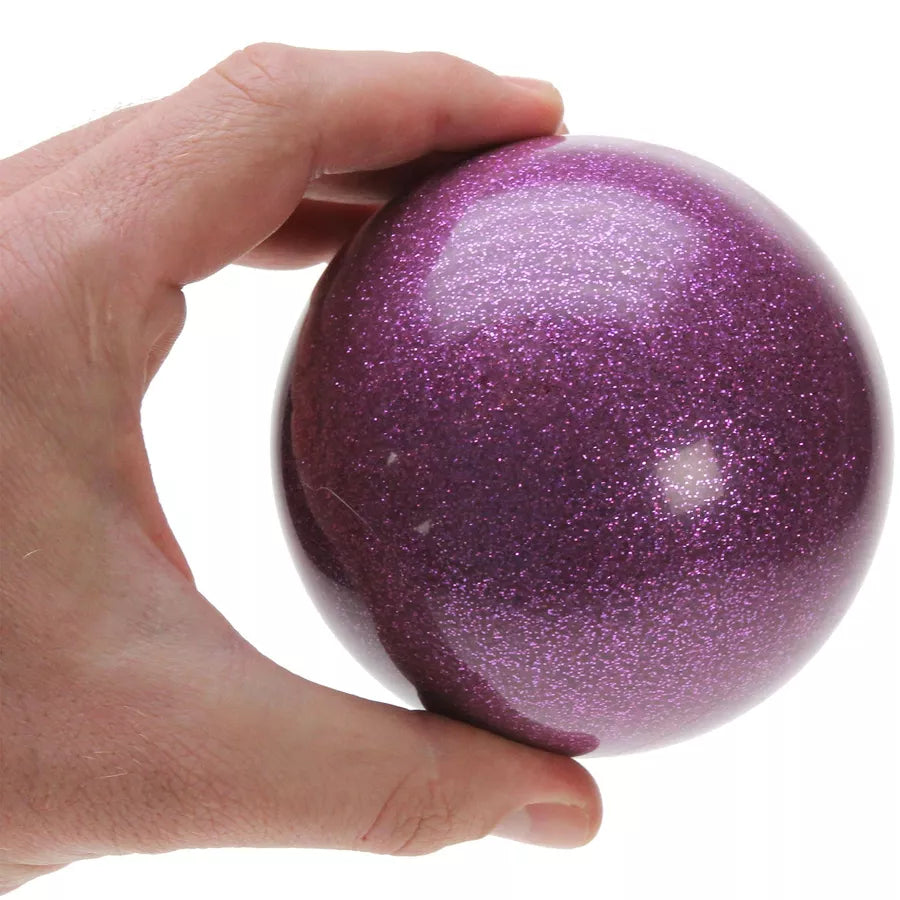 A hand holding a 100mm purple glitter stage ball