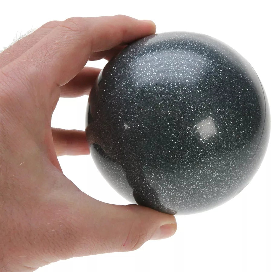 A hand holding a 100mm black glitter stage ball