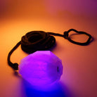 Purple glowing dart with a black rope on an orange background
