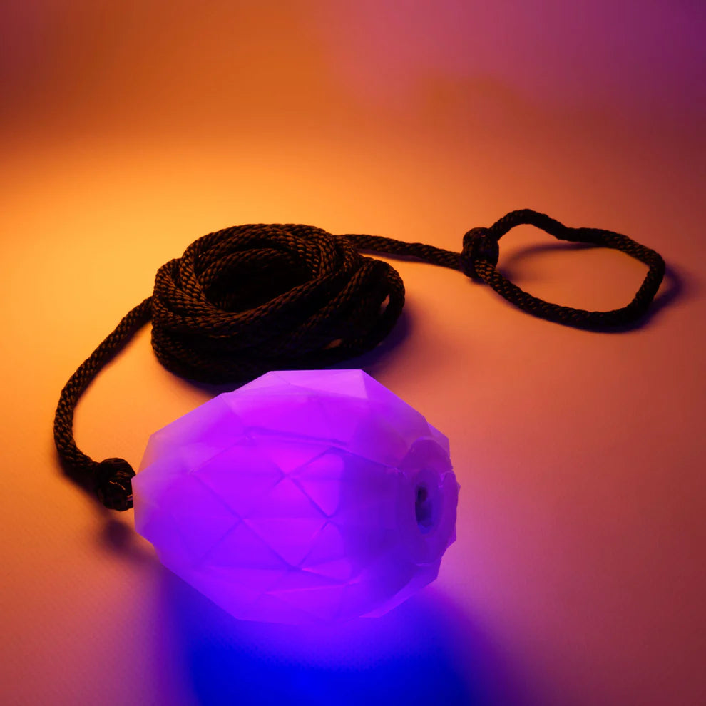 Purple glowing dart with a black rope on an orange background