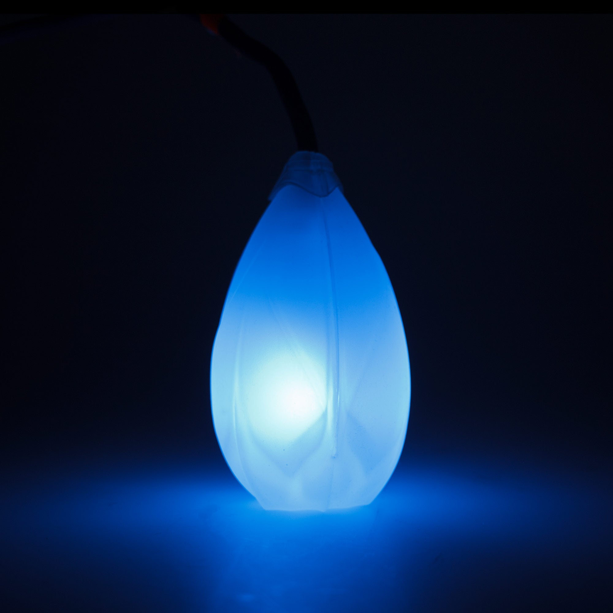 single Flowtoys Podpoi v2 glowing blue and illuminating the table