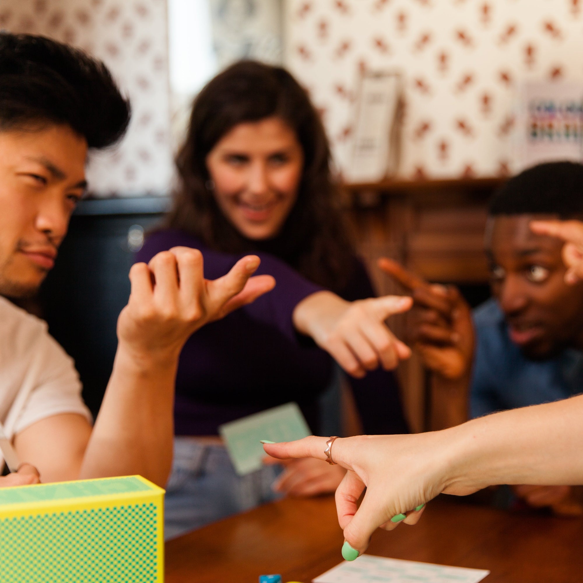 People playing a card game with a focus on hand gestures.