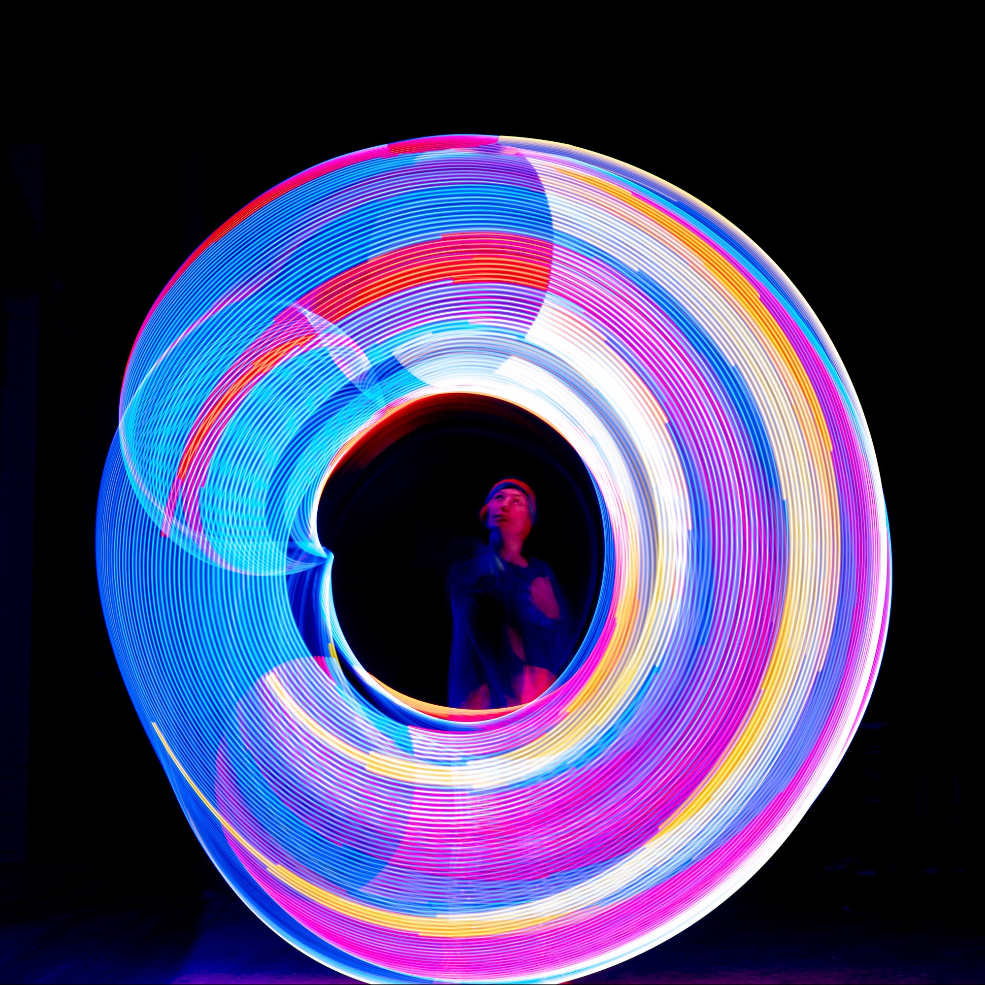 hoop spinning with very bright light trails illuminating the performer