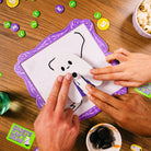 Two hands interacting with a game on a wooden table.