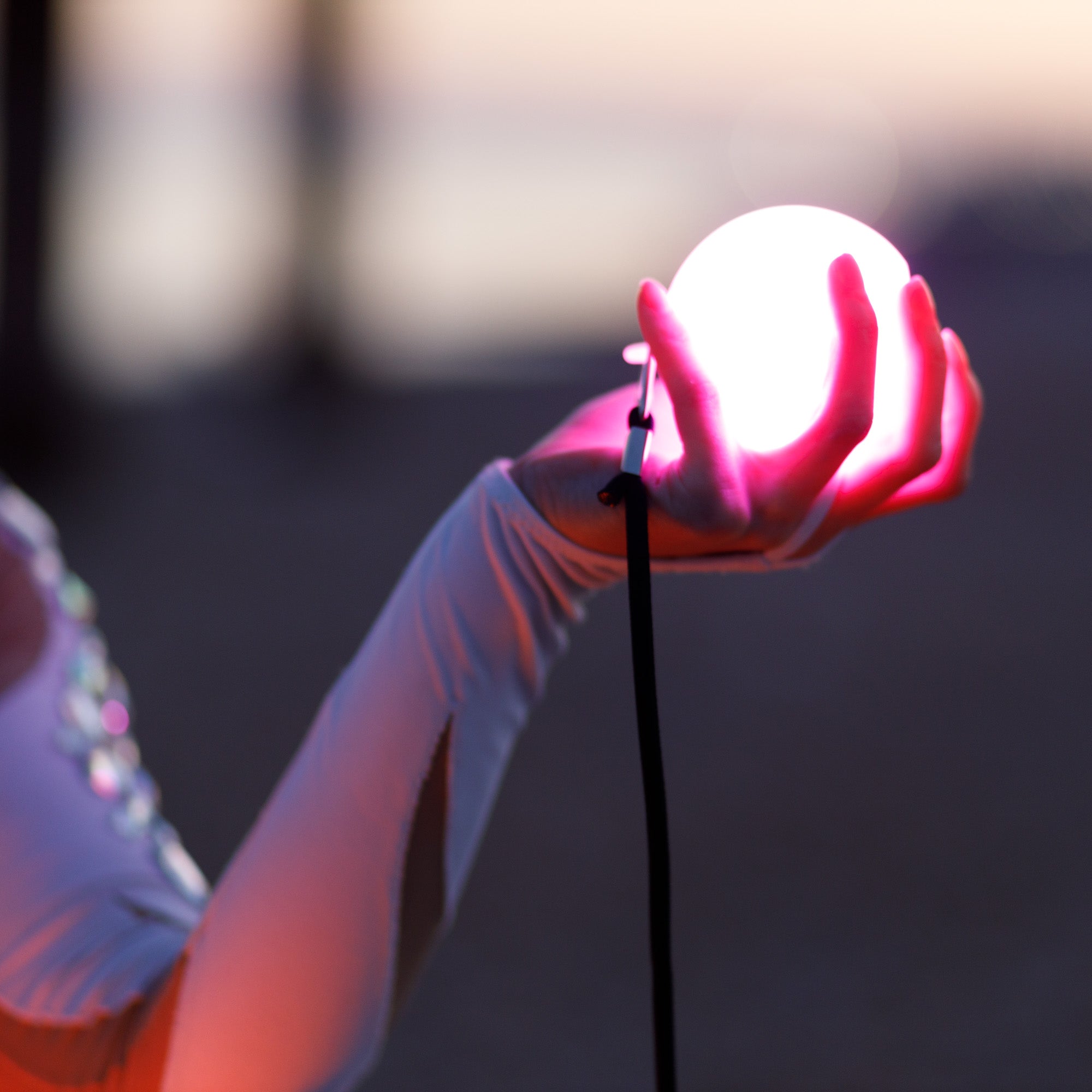 glow poi glowing brightly in a performers hand