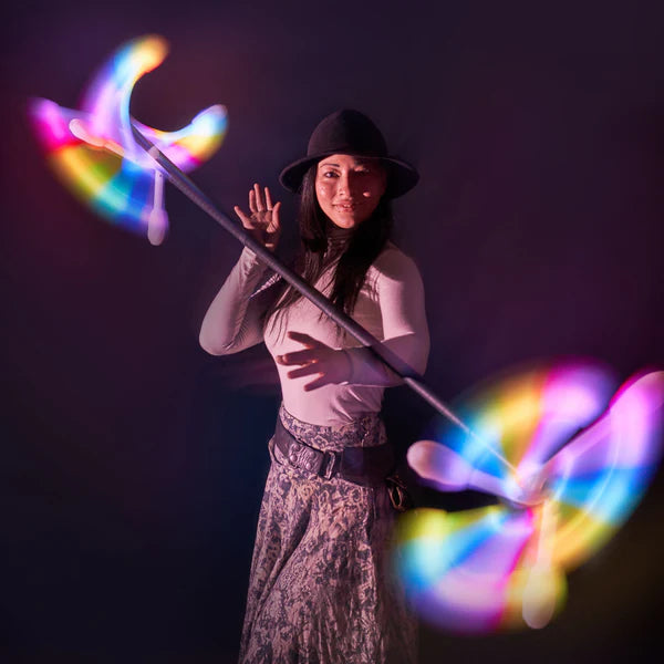 Person holding a glowing, colorful staff against a dark background